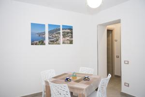 a white dining room with a table and white chairs at beb I Due Fratelli in Vietri sul Mare