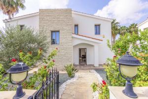 an exterior view of a house with a fence and flowers at Villa Christina Coral in Peyia