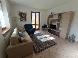 een woonkamer met een bank en een tv bij Villa Irma in Levico Terme