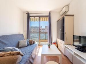 Una sala de estar con un sofá y un televisor. en Apartment Saint James-14 by Interhome, en Le Lavandou
