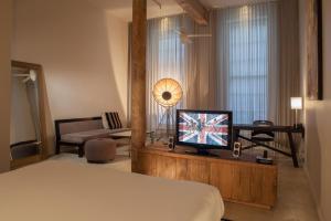um quarto de hotel com uma cama e uma televisão em Loft 523 em Nova Orleans