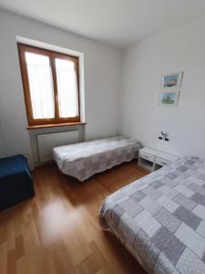 een slaapkamer met 2 bedden en een raam bij Villa Irma in Levico Terme