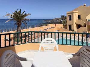 a balcony with a table and chairs and a view of the beach at CT Las Tres Palmeras in Valle Gran Rey