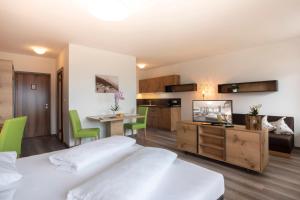 1 dormitorio con 2 camas, cocina y mesa en Hotel Schönbrunn, en Scena