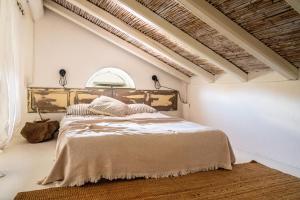 a bedroom with a large bed in a white room at CASA MANORGAI DUE in Orosei
