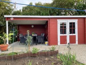 een rode schuur met een tafel en stoelen erin bij Ferienwohung Marina in Großwoltersdorf