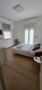 Un dormitorio con una cama grande en una habitación blanca. en A Casa Di Viola, en Casalecchio di Reno 5 fotos más
