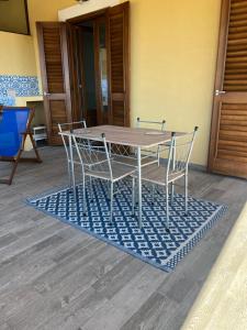een houten tafel en stoelen op een blauw tapijt bij Casa ISABELLA loc turist br in Lipari