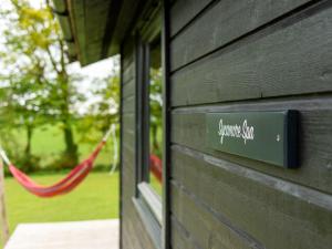 a sign on the side of a building with a hammock at Chalet Sycamore Hot Tub Lodge by Interhome in Launceston
