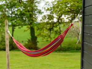 ローンセストンにあるChalet Sycamore Hot Tub Lodge by Interhomeの庭の柱にぶら下がった赤いハンモック +43枚の写真