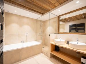 a bathroom with two sinks and a tub at Apartment Le Canvolan-1 by Interhome in Tignes
