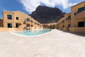 a swimming pool with a mountain in the background at CT Las Tres Palmeras in Valle Gran Rey