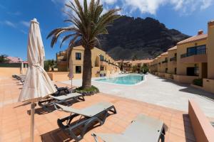 a resort with a palm tree and a swimming pool at CT Las Tres Palmeras in Valle Gran Rey