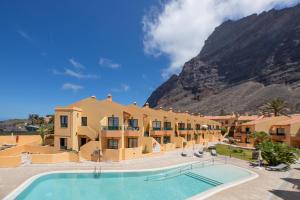 a resort with a pool and mountains in the background at CT Las Tres Palmeras in Valle Gran Rey