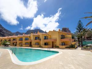 un resort con piscina di fronte a un edificio di Complejo Las Tres Palmeras a Valle Gran Rey