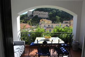 a balcony with a table and a view of a city at Jungle Rooms in Cetara