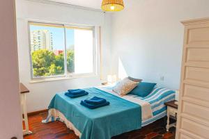a bedroom with a bed with blue sheets and a window at Apartamento en Aguadulce con vistas al mar in Aguadulce