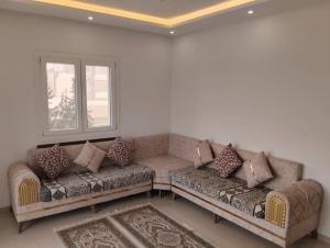 a living room with a couch and a window at Résidence Sousse in El Ahmar