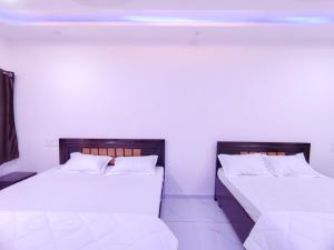 two beds sitting next to each other in a room at Family Homestay in Garudeshwar