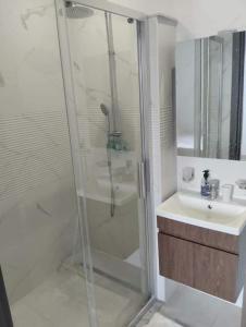 uma casa de banho com um chuveiro e um lavatório. em Résidence Sousse em El Ahmar