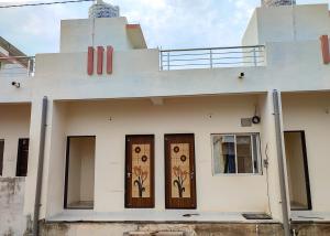 a building with two doors with flowers painted on it at Family Homestay in Garudeshwar