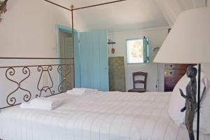 a bedroom with a white bed and a blue door at Casa da Horta in Carvalhal