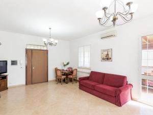 a living room with a red couch and a table at Holiday Home Lungo l'Ardeatina by Interhome in Rome +19 photos