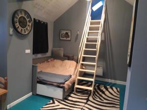 Schlafzimmer mit einer Leiter, die zu einem Etagenbett führt in der Unterkunft Apartement à Theuville-Baigneaux in Theuville