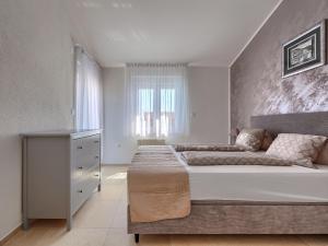 een slaapkamer met een groot bed en een raam bij Villa Dzana by Interhome in Mednjan