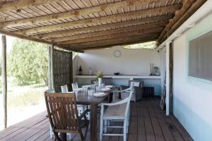 a dining room with a table and chairs on a deck at Casa da Horta in Carvalhal