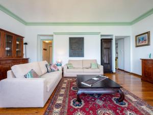 Una sala de estar con dos sofás blancos y una mesa de café. en Apartment Villa Ceriana-3 by Interhome, en Ghiffa