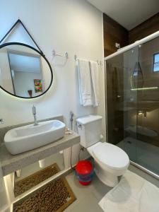 uma casa de banho com um WC, um lavatório e um chuveiro em Pousada Le Baron na Praia do Francês