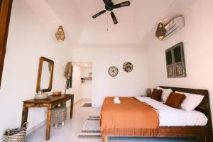 a bedroom with a bed and a mirror and a table at Olo Surf Nature in Uluwatu