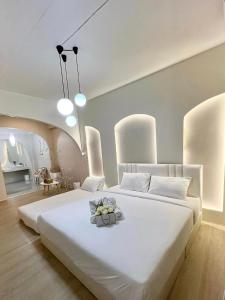 sypialnia z dużym białym łóżkiem i pokój z umywalką w obiekcie 24Rooms นครสวรรค์ w mieście Nakhon Sawan
