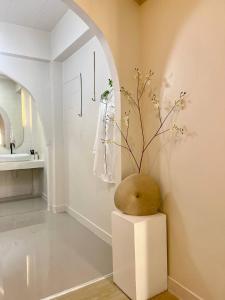 24Rooms นครสวรรค์ في ناخون صوان: غرفة بها مزهرية جالسة على منصة في الحمام