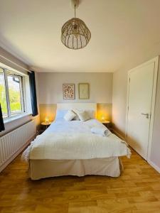 um quarto com uma cama grande e uma luz pendente em Stunning semi-detached townhouse, Holywood, Sleeps 6 - 10 mins from Belfast em Belfast
