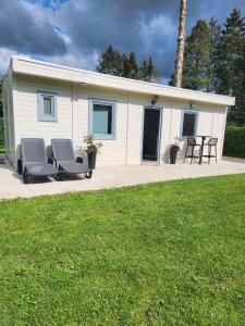 une petite maison avec 2 chaises et une terrasse dans l'établissement LE GLAWAN, à Barvaux