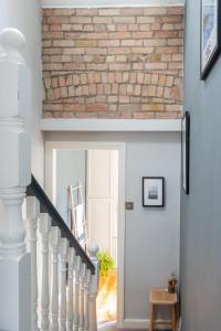 uma escada branca com uma parede de tijolos e uma porta em GuestReady - Victorian redbrick in heart of Dublin em Dublin