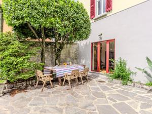 a table and chairs on a patio with a tree at Apartment Regina 29 by Interhome in Mezzegra