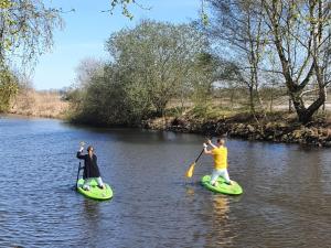 two people are on paddle boards on a river at Holiday Home Lethehuis by Interhome in Vlagtwedde