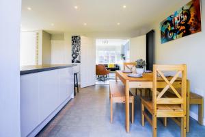 a kitchen with a table and a dining room at Spacious 4 Bedroom Home in Milton Keynes with Free Off Street Parking by HP Accommodation in Milton Keynes