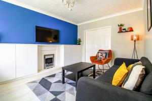 a living room with a couch and a table at Spacious 4 Bedroom Home in Milton Keynes with Free Off Street Parking by HP Accommodation in Milton Keynes