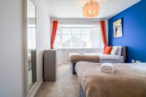 Un dormitorio con dos camas y una pared azul. en Host & Stay - Wilshire Way, en Milton Keynes 29 fotos más