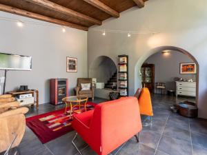 a living room with a red couch and orange chairs at Holiday Home Beppe Country House by Interhome in Serravalle dʼAsti