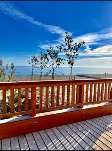 un banco de madera sentado en un paseo marítimo cerca de la playa en Apartamento Sol, Benajarafe, en Benajarafe