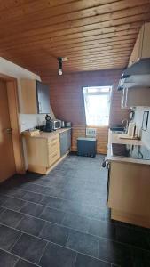 a large kitchen with a tile floor and wooden ceilings at Cosy Retreat in Friolzheim in Friolzheim