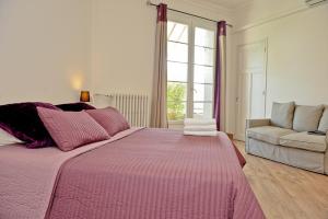 - une chambre avec un lit rose et un canapé dans l'établissement Appartement Les Hortensias, à Avignon