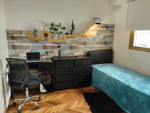 una camera da letto con scrivania, letto e sedia di Verde Almagro dos cuartos a Buenos Aires