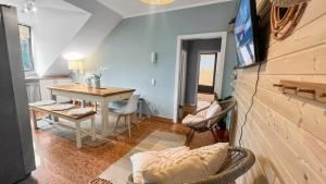 een woonkamer met een tafel en een tv aan de muur bij Flatista Homes - Penthouse with Rooftop Gym in München