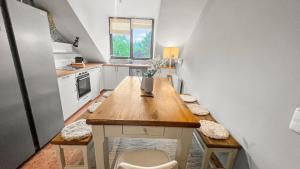 een kleine keuken met een houten tafel in een kamer bij Flatista Homes - Penthouse with Rooftop Gym in München